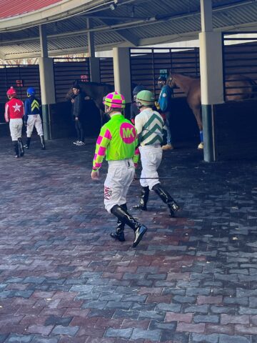 Picture of jockeys walking to their horses.