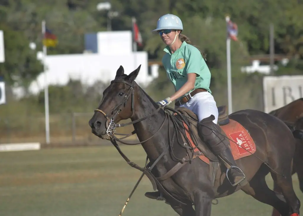 picture of a smiling polo player riding her horse during a match, polo surely doesn't seem like a cruel sport,