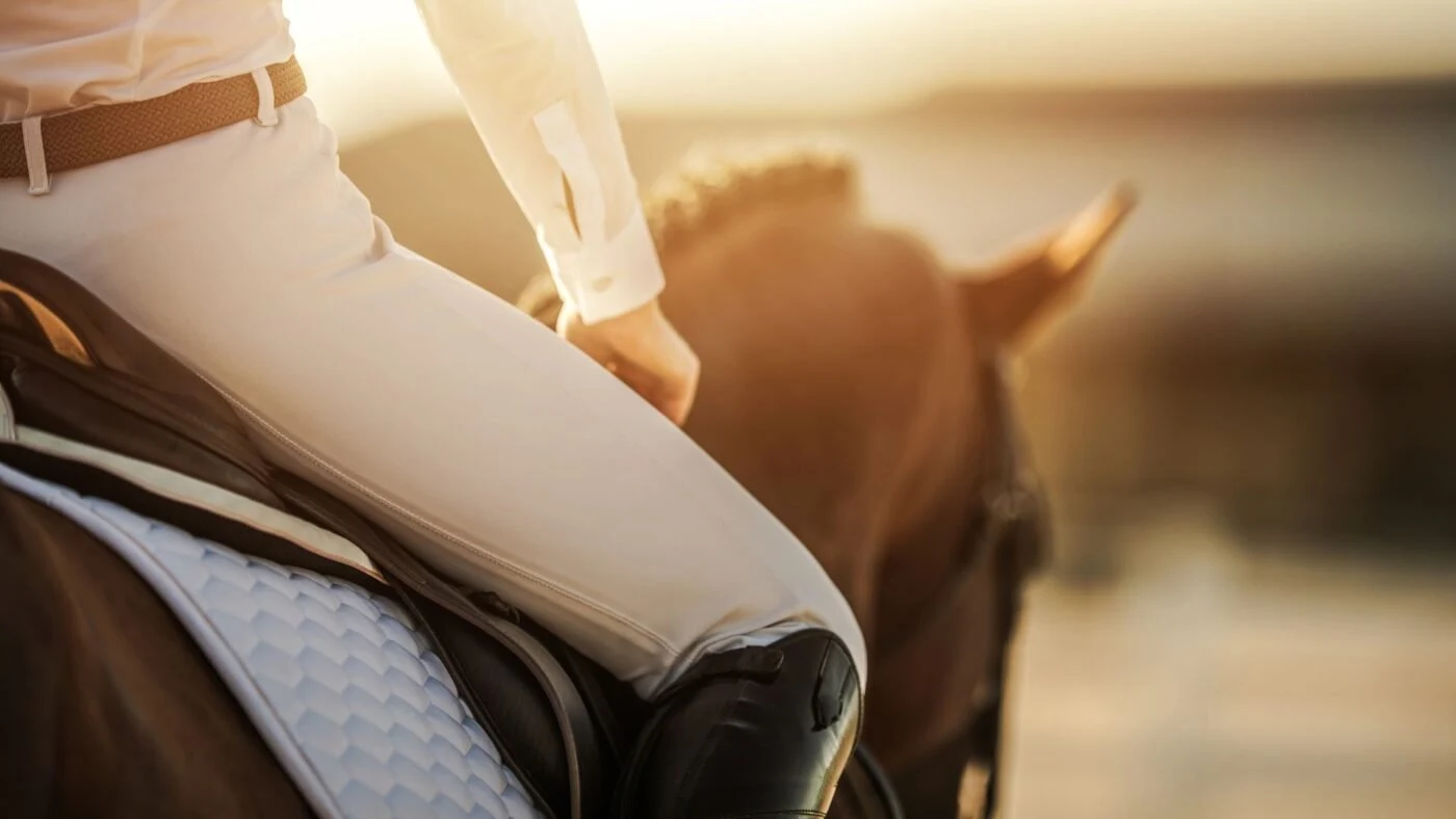Female rider wearing silicone-grip horse riding tights during arena training