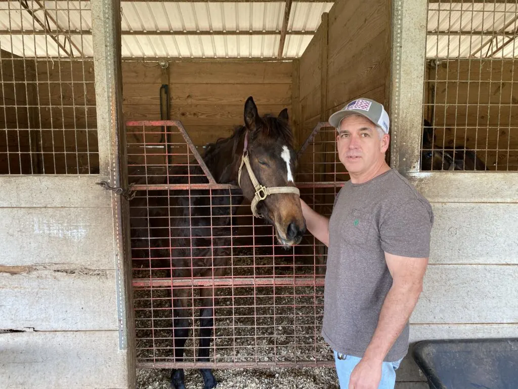 Picture of me (Miles Henry) with one of our racehorses in the barn.