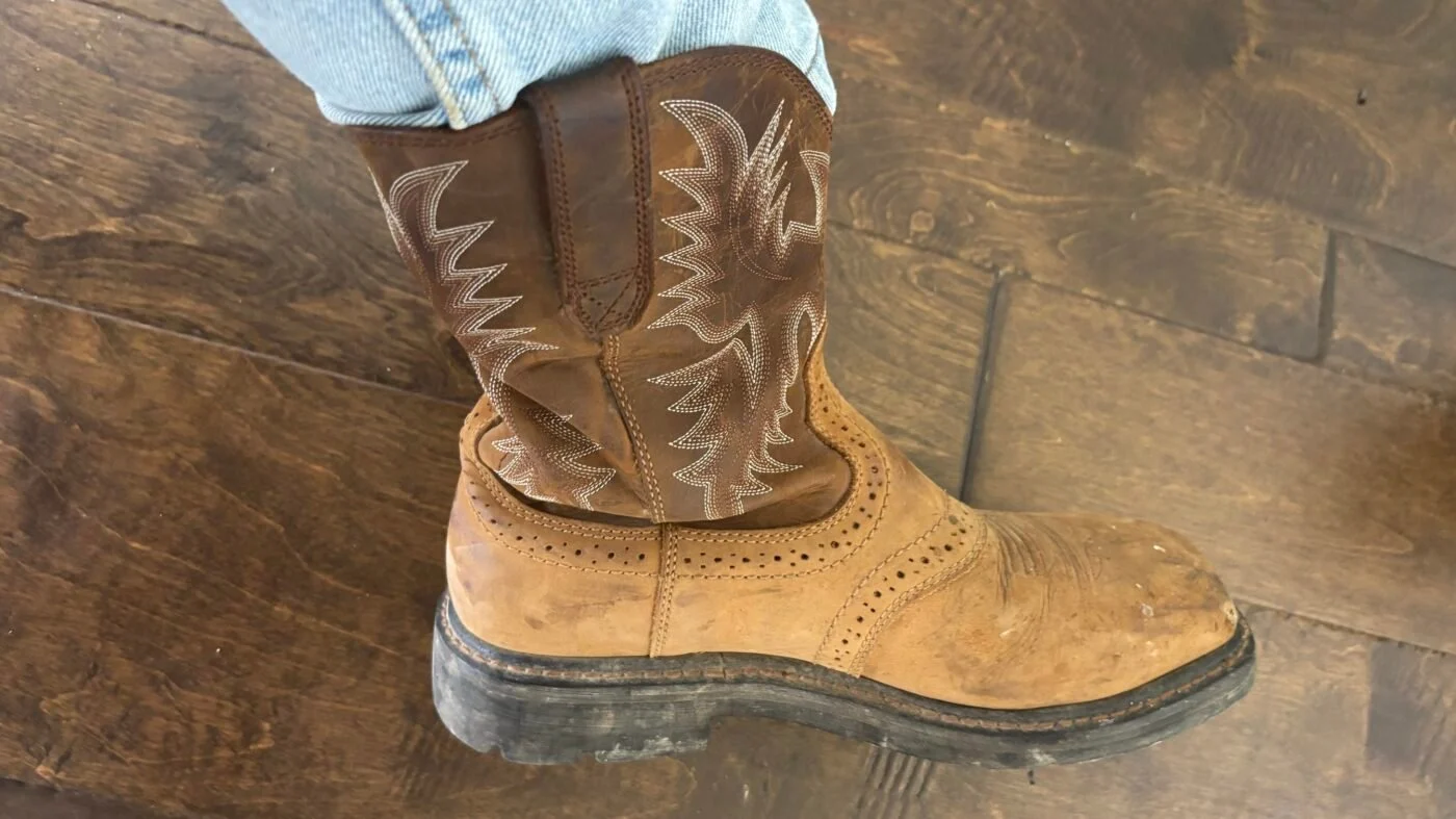 Ariat Sierra work boots on person's feet showing normal half-inch heel slip during first week of break-in period