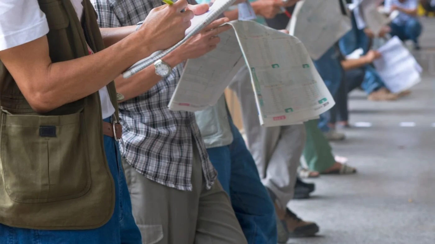 Beginner handicapper reviewing race program at Churchill Downs