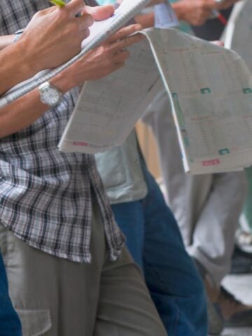 Beginner handicapper reviewing a race program at the racetrack