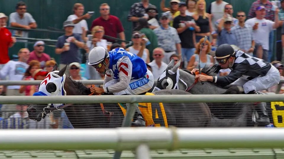 Thoroughbred horses rounding the turn on the dirt track during the Breeders' Cup World Championships at Santa Anita Park.