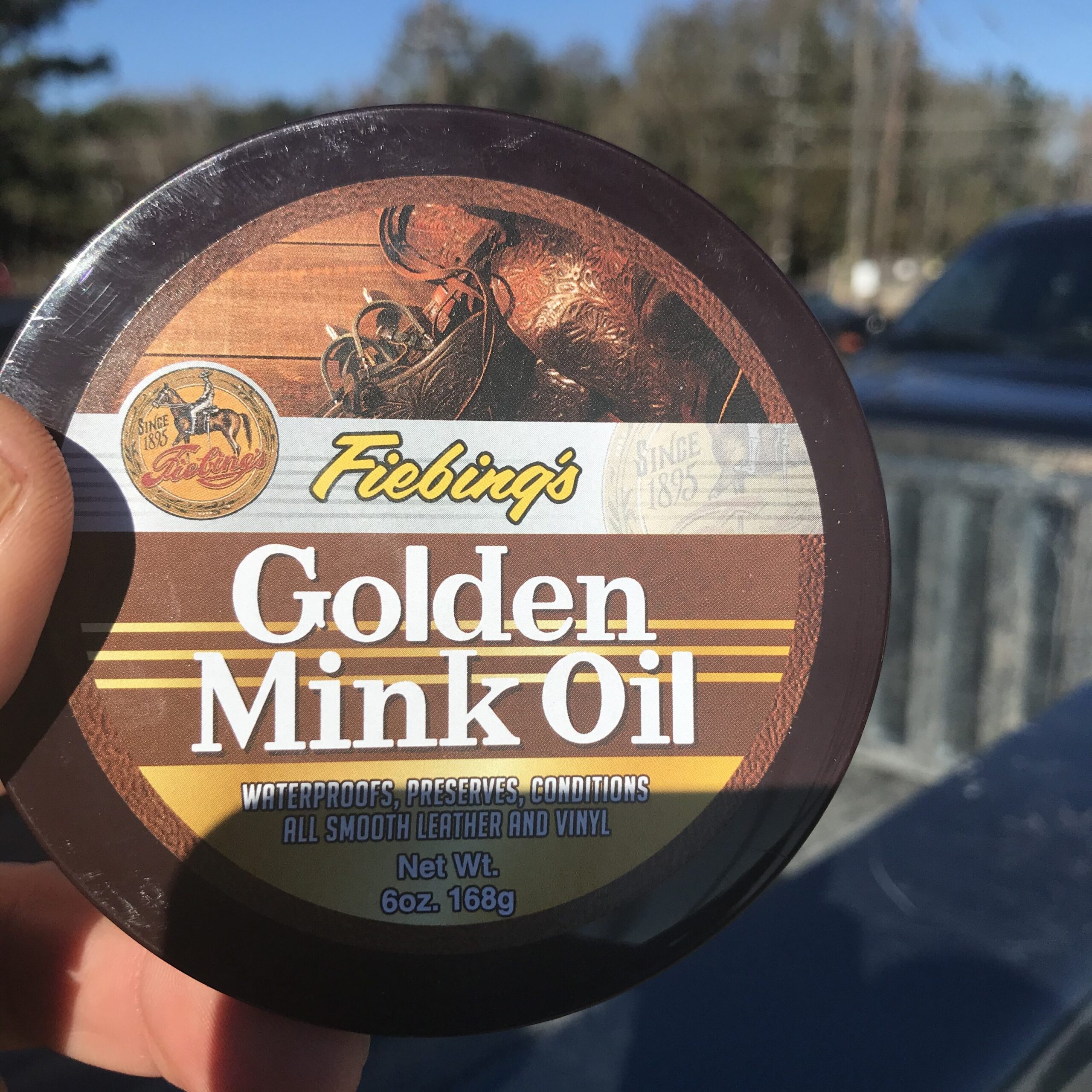 Can of Fiebing's mink oil used to condition and improve water resistance in leather work boots